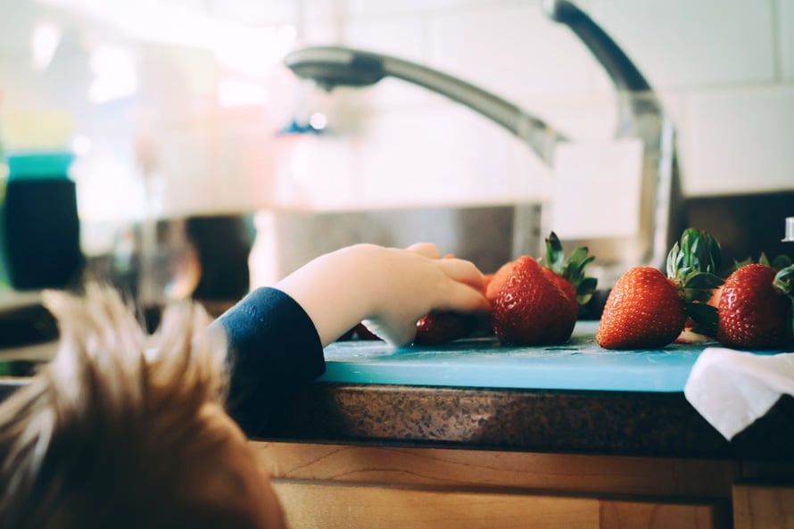 Kid-reaches-to-take-fruit-off-of-plate