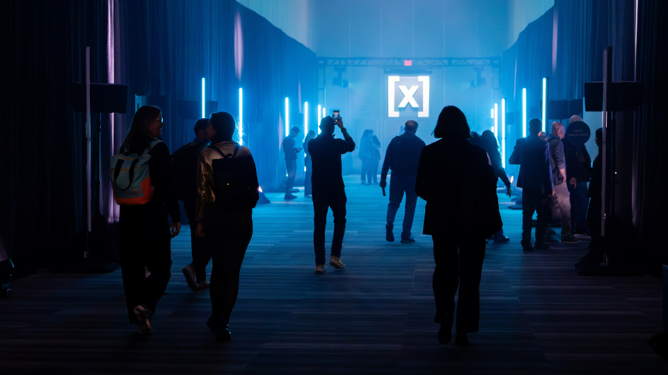 Event attendees walking into HumanX through an entrance experience with bright aesthetic lighting