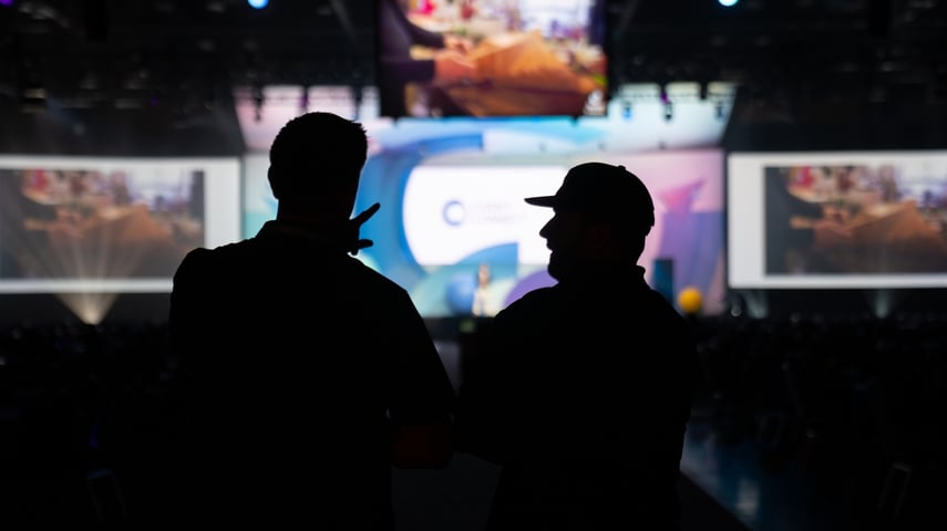Silhouette of Clarity Experiences technicians near the general session stage at Cvent Connect 2024